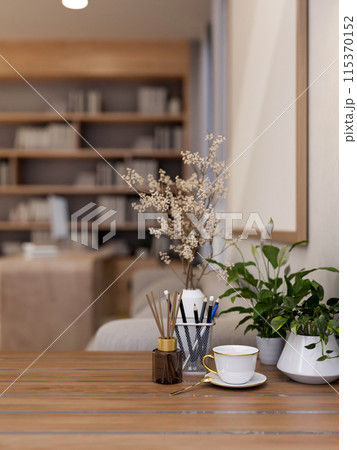 A wooden table features decorative objects in a modern, luxurious living room. A wooden table features decorative objects in a modern, luxurious living room. 115370152