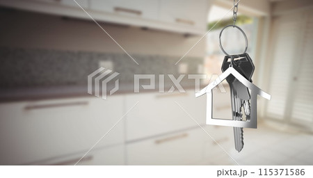 Image of silver house keys and house shaped key fob hanging over an out focus kitchen 4k 115371586