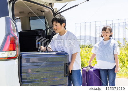 トランクに荷物を入れる子ども child putting luggage in trunk トランクに荷物を入れる子ども child putting luggage in trunk 115371910