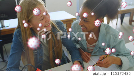 Image of Covid 19 coronavirus cells spreading over two female students working together 115373486