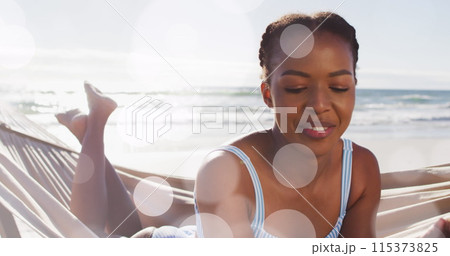 Image of dots over happy african american woman in hammock on beach 115373825