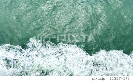 waves of the sea or ocean from under the ship floating quickly on the waves puffs of water with white foam the water itself Emerald Green very beautiful background for any travel text travel agency waves of the sea or ocean from under the ship floating quickly on the waves puffs of water with white foam the water itself Emerald Green very beautiful background for any travel text travel agency 115374173