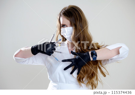 Beautiful woman dentist in a black suit with a white mask with flowing hair holds in her hands scaler and curette Hand stretched forward selective focus bright photo of gorgeous woman Beautiful woman dentist in a black suit with a white mask with flowing hair holds in her hands scaler and curette Hand stretched forward selective focus bright photo of gorgeous woman 115374436