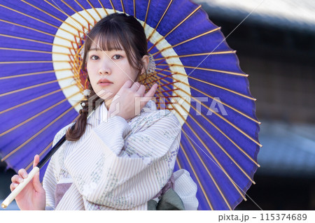 和傘をさしてポーズをとる着物姿の若い女性 115374689