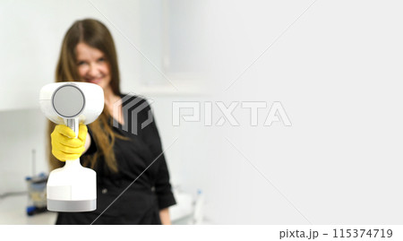 portable x-ray beautiful young female doctor in her hands with a portable x-ray prepared to take a picture for an advertisement banner beautifully interesting bright space for text white background 115374719