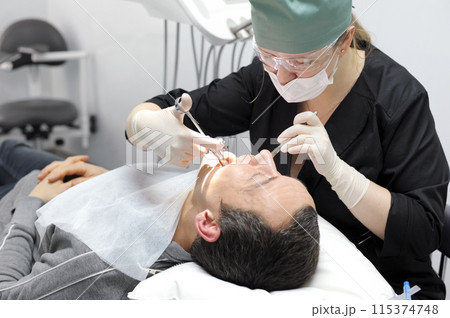 dentistry office tools woman doctor injects anesthesia with carpool syringe to patient dental operation dentistry office tools woman doctor injects anesthesia with carpool syringe to patient dental operation 115374748