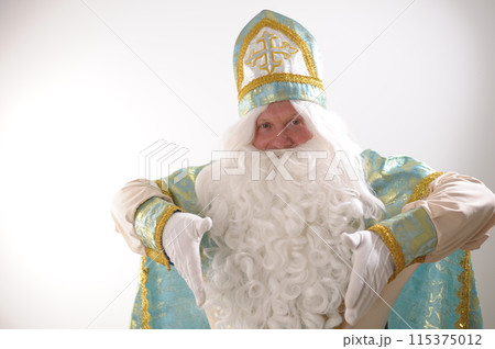 Fairy tale 12 months Nicholas the Wonderworker, Saint Nicholas Lights the stars with his fingers, throwing them in different directions, look at the camera and shows attention look founder of Santa 115375012