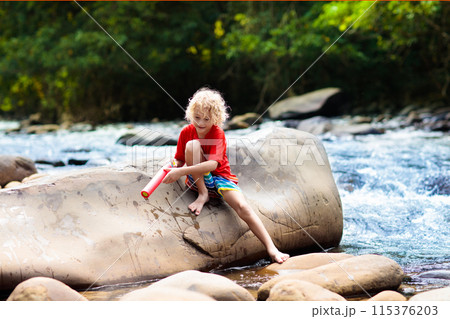 Child hiking in mountains. Kids at river shore. Child hiking in mountains. Kids at river shore. 115376203