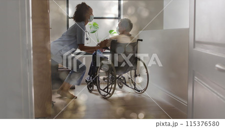 Image of bokeh over diverse doctor and patient sitting in wheelchair 115376580