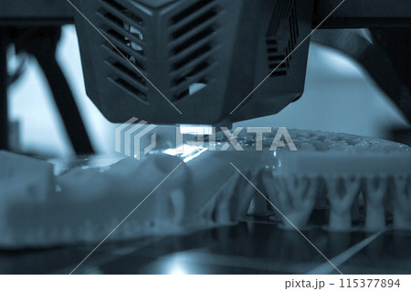 3D printer printing a model. Equipment of a 3D printer during the process of printing a model from molten plastic 3D printer printing a model. Equipment of a 3D printer during the process of printing a model from molten plastic 115377894