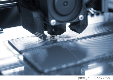 3D printer printing a model. Equipment of a 3D printer during the process of printing a model from molten plastic 3D printer printing a model. Equipment of a 3D printer during the process of printing a model from molten plastic 115377899