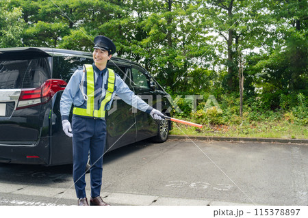 駐車場で誘導する警備員 115378897