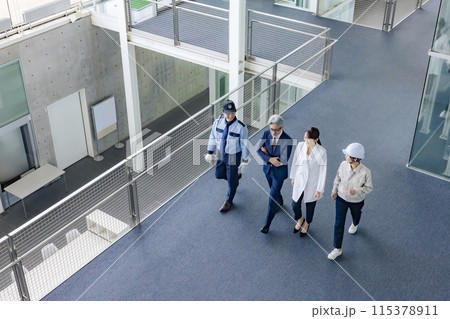 ロビーを歩く様々な職業の人々（ビジネスマン・エンジニア・研究者・警備員） 115378911