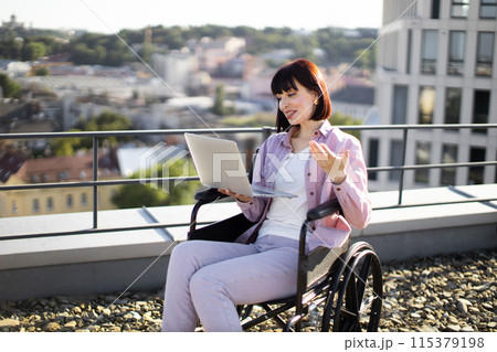 Young woman in wheelchair has video chat during business conference. 115379198