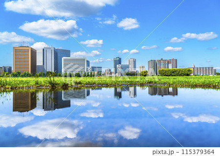 雨上がりの川崎の都市風景　水たまりに映る街並み【神奈川県・川崎市】 115379364