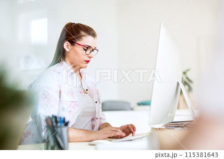 Young businesswoman working on laptop in a startup company office. Working in co-working space. 115381643