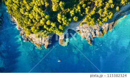 Drone view of the sea coast. Rocky shore and sea water. Vacation and travel. 115382324