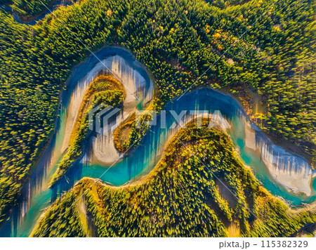 Drone view of the river in the forest. An aerial view of an woods. Winding river among the trees. 115382329
