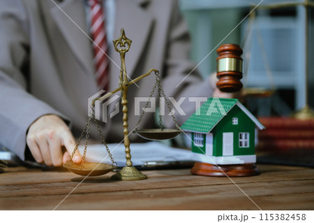 Justice and law concept. Real Estate Law in a courtroom the gavel, working with digital tablet computer on wood table in sun light. 115382458