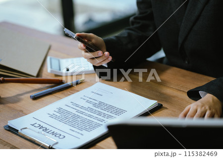 Justice and law concept. male judge in a courtroom with the gavel working with digital tablet computer and smartphone on wood table. Justice and law concept. male judge in a courtroom with the gavel working with digital tablet computer and smartphone on wood table. 115382469