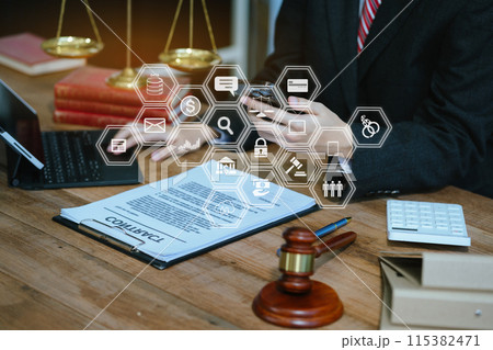 Justice and law concept. male judge in a courtroom with the gavel working with digital tablet computer and smartphone on wood table. Justice and law concept. male judge in a courtroom with the gavel working with digital tablet computer and smartphone on wood table. 115382471