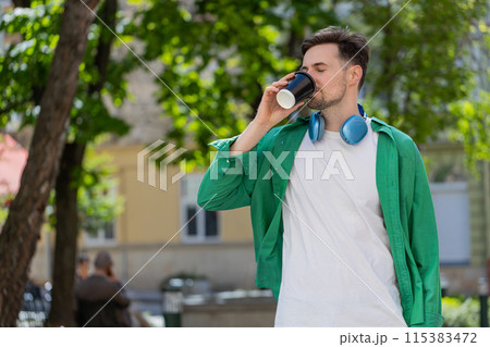 Happy man enjoying morning coffee hot drink and smiling relaxing, taking a break on city street 115383472