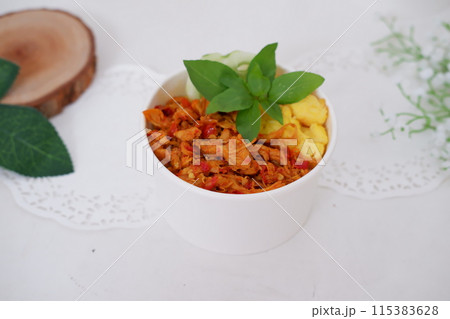 rice with sliced spicy chicken and vegetables as a background 115383628