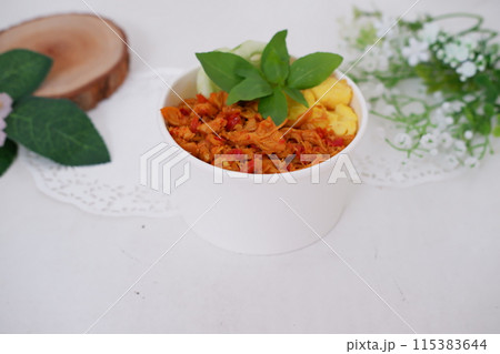 rice with sliced spicy chicken and vegetables as a background 115383644