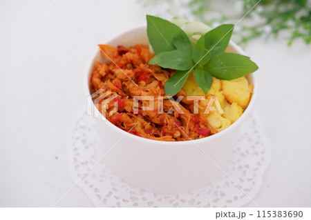 rice with sliced spicy chicken and vegetables as a background 115383690