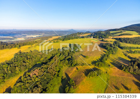 Green hilly landscape with green meadows and forests. Jested ridge near Liberec, Czechia. Aerial view from drone. 115384339