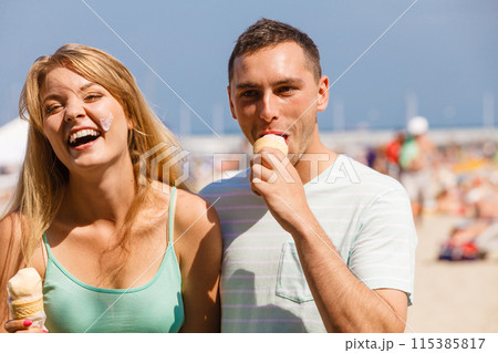 Man and woman eating ice cream on beach 115385817