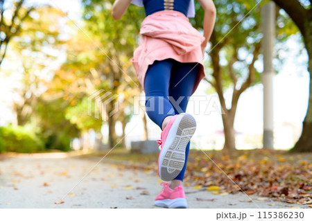秋の公園の街路樹の道をジョギングする若い女性の足元 ダイエット ボディメイク 秋の公園の街路樹の道をジョギングする若い女性の足元 ダイエット ボディメイク 115386230