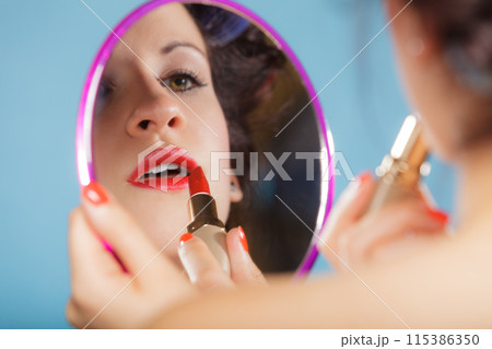 Woman applying red lipstick Woman applying red lipstick 115386350