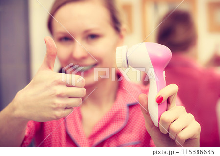 Woman holding facial cleansing brush Woman holding facial cleansing brush 115386635