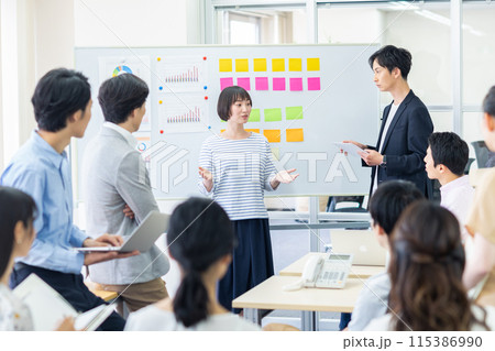 大人数の前でプレゼンする若い女性 大人数の前でプレゼンする若い女性 115386990