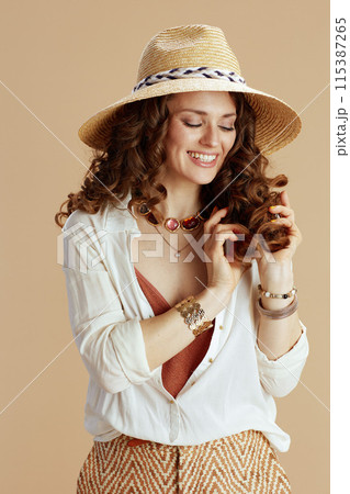 smiling stylish woman in blouse and shorts on beige smiling stylish woman in blouse and shorts on beige 115387265