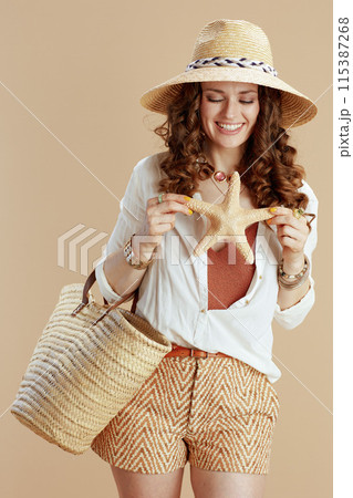 smiling stylish woman in blouse and shorts isolated on beige smiling stylish woman in blouse and shorts isolated on beige 115387268