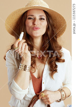 smiling trendy woman in blouse and shorts isolated on beige smiling trendy woman in blouse and shorts isolated on beige 115387273