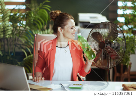 happy modern woman worker in modern green office in red jacket happy modern woman worker in modern green office in red jacket 115387361