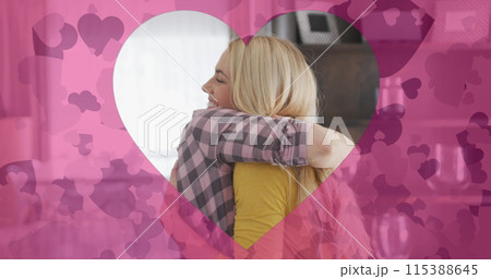 Image of heart shapes over happy caucasian mother and adult daughter hugging at home 115388645