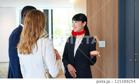 受付で外国人宿泊客に接客する女性スタッフ 115389254