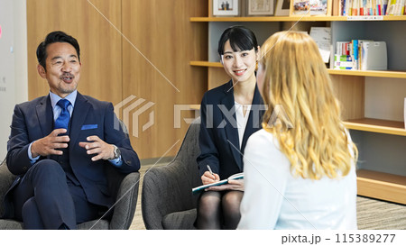 ロビーで通訳を介して会話する多国籍ビジネスパーソンのグループ ロビーで通訳を介して会話する多国籍ビジネスパーソンのグループ 115389277