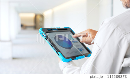タブレットを見ながら建物をチェックするエンジニア 115389278