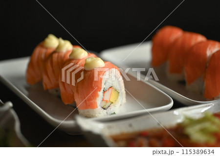 Delicious California salmon roll served on a white plate. Traditional Japanese cuisine concept Delicious California salmon roll served on a white plate. Traditional Japanese cuisine concept 115389634