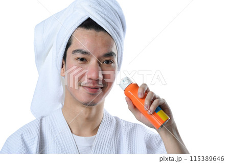 Smiling young man holding spray bottle of sunscreen isolate on white background 115389646