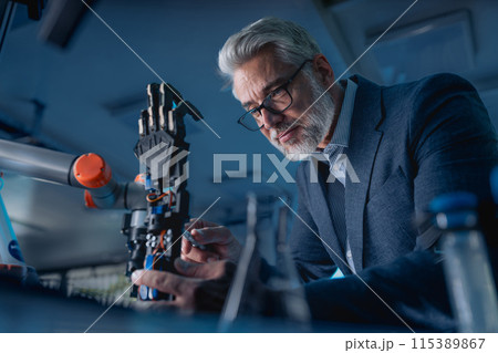 Robotics engineer adjusting, calibring robotic prosthetic hand. Concept of modern technology in medicine. Robotic prosthetics, biomechatronics and neuroscience. Robotics engineer adjusting, calibring robotic prosthetic hand. Concept of modern technology in medicine. Robotic prosthetics, biomechatronics and neuroscience. 115389867