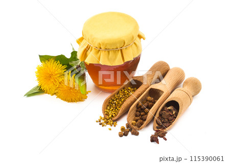 A jar of honey with fabric lid, pollen granules, beebread, and dandelion flowers 115390061