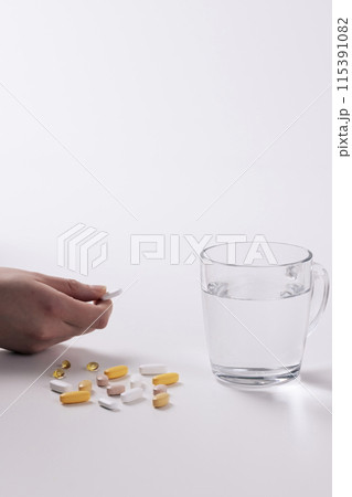 Picking up a pill with your hand Picking up a pill with your hand 115391082