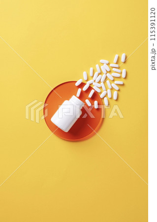 the white pills pouring out of the vat 115391120