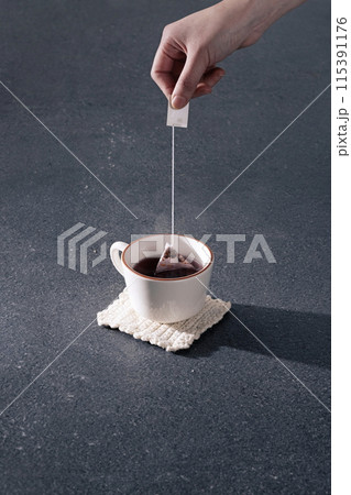 making a flower tea bag in a teacup 115391176